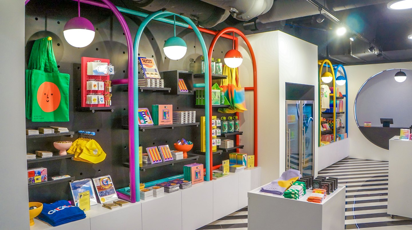 Colorful merchandise displayed on black pegboard walls inside a shop.