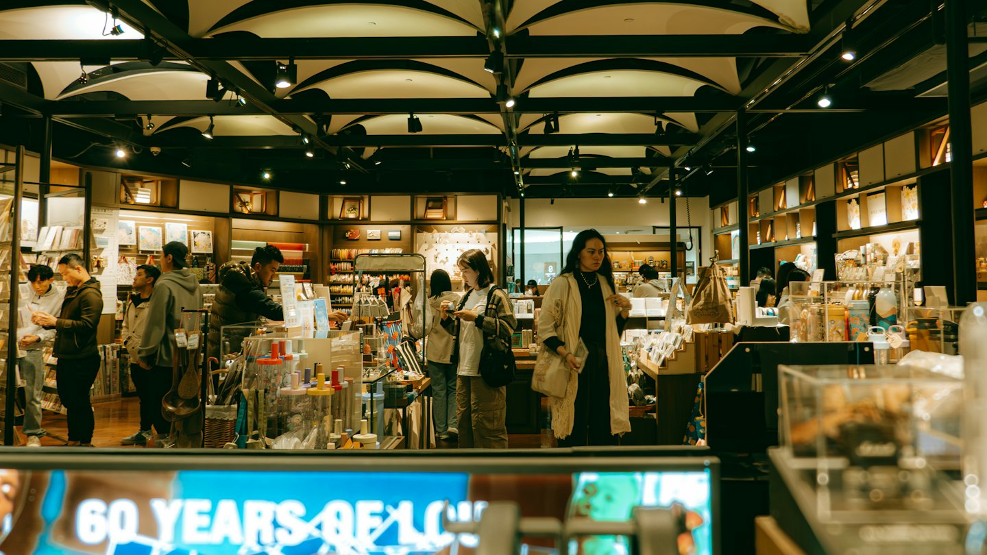Customers browse products displayed on shelves inside a modern store.